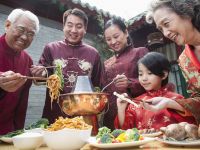 Family Enjoying Meal In Traditional Chinese Clothing